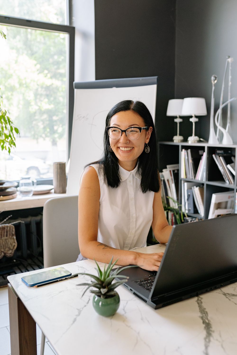 A business professional working at a laptop in a bright office