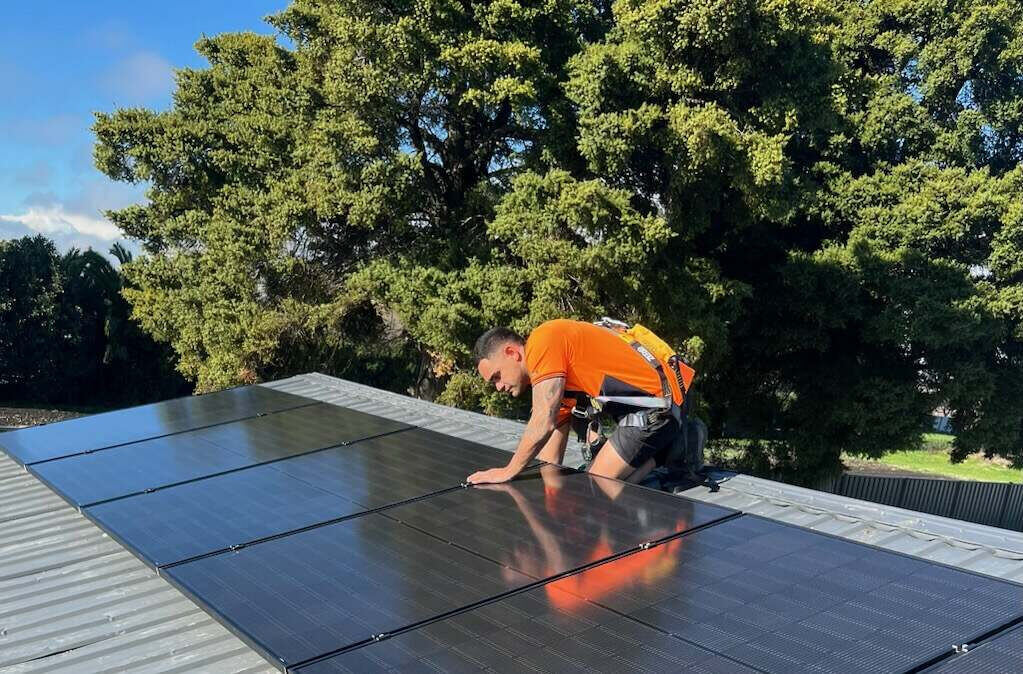 NZ solar installer working on a roof — service businesses win local customers through their Google Business Profile